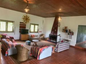 - un salon avec des canapés et une cheminée dans l'établissement Casa de Fazenda na Ecovila Sustentar, 38km de SP, à Embu-Guaçu