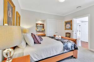 um quarto com uma grande cama branca com almofadas em Addlestone House - St Mary's em Saint Marys