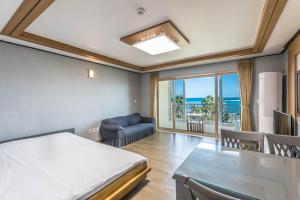 1 dormitorio con cama, sofá y mesa en Sea Eco Beach, en Jeju