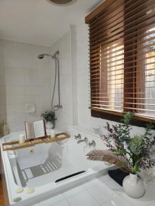 a bathroom with a bath tub with a book on it at Daylesford - FROG HOLLOW ESTATE - The Homestead in Daylesford