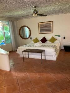 a bedroom with a bed with a table and a mirror at Maria's Kan Kin in Isla Mujeres