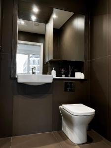 ein Badezimmer mit einem weißen WC und einem Waschbecken in der Unterkunft Spacious 2 Bedroom Penthouse Retreat in London