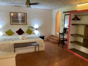 ein Schlafzimmer mit einem Bett und einem Schreibtisch in einem Zimmer in der Unterkunft Maria's Kan Kin in Isla Mujeres