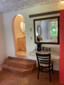 einen Spiegel und einen Stuhl in einem Zimmer mit Bad in der Unterkunft Maria's Kan Kin in Isla Mujeres