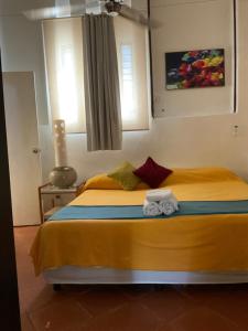 a bedroom with a yellow bed with towels on it at Maria's Kan Kin in Isla Mujeres
