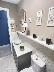 een badkamer met een toilet, een wastafel en een spiegel bij Apartamento prox shopping atlântico BrisamarBC5 in Balneário Camboriú