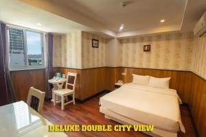 1 dormitorio con cama, mesa y ventana en Golden Rain 2 Hotel, en Nha Trang