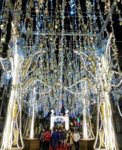 people walking under a large chandelier with christmas lights at casa salvante in Moaña +54 photos