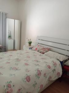 - une chambre dotée d'un lit avec un couvre-lit floral dans l'établissement APTO CABO FRIO PERTO DE TUDO, à Cabo Frio
