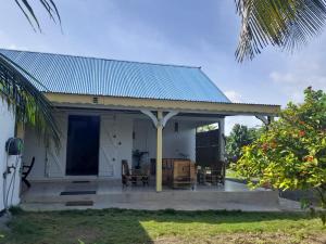 uma pequena casa branca com um telhado azul em Maison bord de mer à 100 m em Saint-François