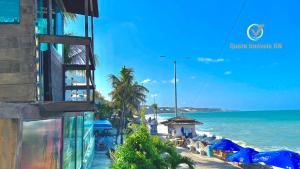 vistas a una playa con sombrillas azules y al océano en Ponta Negra Beach beira-mar ap 216, en Natal