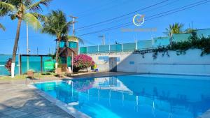 una piscina frente a un edificio con palmeras en Ponta Negra Beach beira-mar ap 216, en Natal