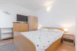 - une chambre avec un lit et une télévision à écran plat dans l'établissement Apartment in Cervar Porat - Istrien 44232, à Poreč