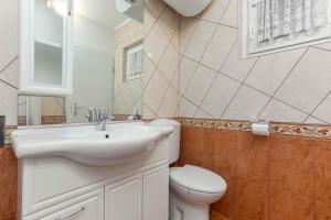 La salle de bains est pourvue d'un lavabo blanc et de toilettes. dans l'établissement Apartment in Cervar Porat - Istrien 44232, à Poreč