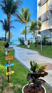 un letrero de la calle con palmeras y un edificio en Ponta Negra Beach beira-mar ap 216, en Natal