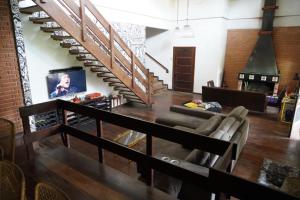 a living room with a couch and a staircase at Casa em Condomínio Estrada de São Roque Estrada do Vinho in São Roque