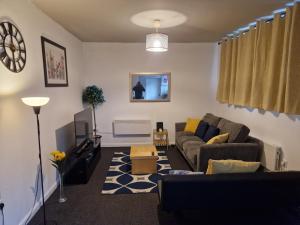 een woonkamer met een bank en een tv bij Primos Suite - Stylish 1 Bedroom in Wallsend in Old Walker