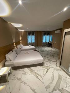 - une grande chambre avec un lit et un grand sol en marbre dans l'établissement Nahdhoh Hotel, à Kubang Semang