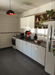eine Küche mit weißen Schränken und einem Kühlschrank in der Unterkunft Dulce Hogar in San Miguel de Tucumán