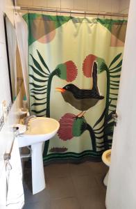 un baño con un pájaro sobre una cortina de ducha en Dulce Hogar en San Miguel de Tucumán