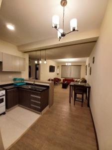 cocina y sala de estar con mesa. en Paseo Recoleta, en Cochabamba
