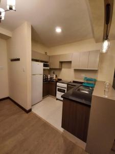 Una cocina con un refrigerador blanco y una estufa. en Paseo Recoleta, en Cochabamba