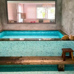 a large swimming pool in a bathroom with a mirror at Emerald House in Rio de Janeiro