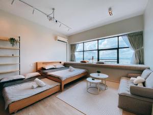 uma sala de estar com duas camas e um sofá em Seafront Country Garden Danga Bay by Lions Bay em Johor Bahru