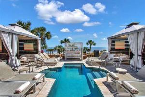 a swimming pool with chaise lounge chairs and a swimming poolvisor at San Luis Sunrise in Galveston