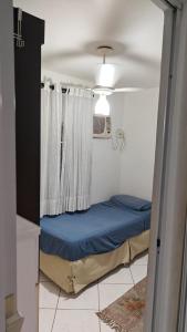 - un petit lit dans une chambre avec fenêtre dans l'établissement Refúgio Santista - sua casa fora de casa com estacionamento, à Santos