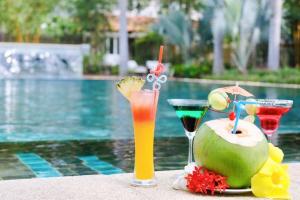 two drinks on a table next to a swimming pool at Full Moon Village Resort in Mui Ne