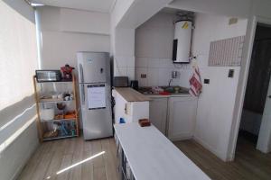 a kitchen with a refrigerator and a table in it at Espectacular vista y central in Viña del Mar