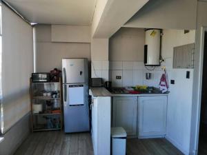 a small kitchen with a refrigerator and a stove at Espectacular vista y central in Viña del Mar