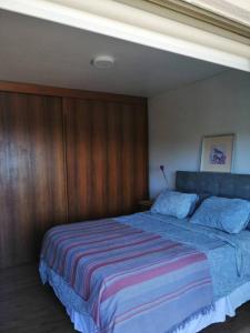 a bedroom with a large bed with a striped blanket at Espectacular vista y central in Viña del Mar