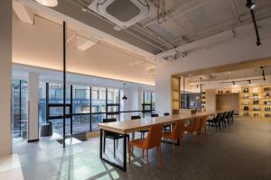 an office space with a long table and chairs at Hangzhou Desti Youth Park Hostel in Hangzhou