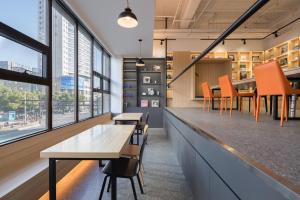 a bar in a restaurant with orange chairs and tables at Hangzhou Desti Youth Park Hostel in Hangzhou