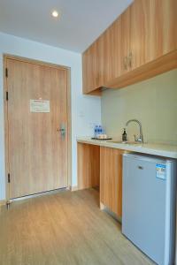a kitchen with a refrigerator and a wooden door at DuoDuo Hotel Apartment - Yiwu International Trade City in Yiwu