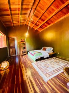 um quarto com uma cama e piso em madeira em Kalis Inn em Alto Paraíso de Goiás