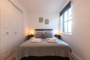 a bedroom with a bed with two towels on it at Marigold- 2 Bedroom, Sleeps 5 in Southampton