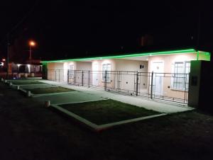 a white building with green lights on it at night at Sol Latino 2 in Victorica