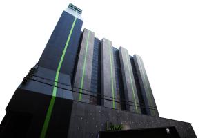 Un edificio alto y negro con líneas verdes. en Lime hotel en Suwon