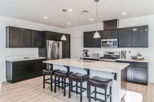 a kitchen with black cabinets and a kitchen island with bar stools at Valley Getaway 15 mins from Napa 10 min from Suisan valley large backyard with fire pit and more in Fairfield