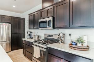 a kitchen with stainless steel appliances and black cabinets at Modern family-friendly home, Napa, wine country, private backyard, fire pit in Fairfield