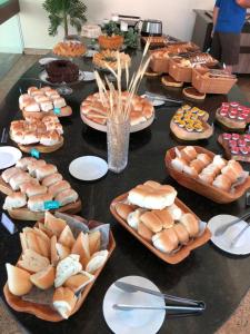 einen Tisch mit Teller mit Brot und Gebäck in der Unterkunft Flat térreo 2 quartos no Resort Marulhos - Porto de Galinhas in Porto De Galinhas