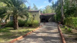 聖塔安娜的住宿－LA INESITA，棕榈树和车道的房子