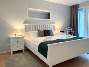 a bedroom with a large white bed and a window at Haus Nordseebrandung FeWo C2 2 in Cuxhaven