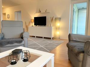a living room with two chairs and a television at Haus Nordseebrandung FeWo C2 2 in Cuxhaven