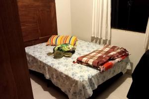 uma pequena cama com um cobertor e almofadas em Casa em Balneário Camboriú em Balneário Camboriú