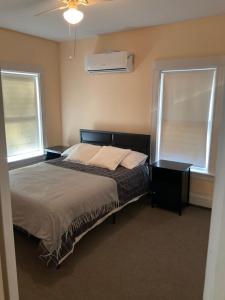 1 dormitorio con 1 cama y 2 ventanas en Comfortable place to stay, en Milford