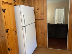 a white refrigerator in a room with wooden walls at Comfortable place to stay in Milford